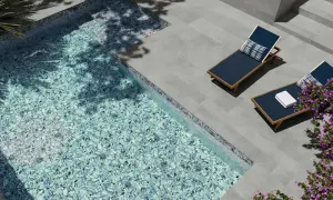 Modernas ideas de piscinas: piscina con mosaico azul brillante, tumbonas y flores moradas.