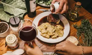 Elegancka kolacja: steka w sosie winnym, ravioli, kieliszek czerwonego wina. Idealny moment, kiedy dodać wino do mięsa, by wzbogacić smak.