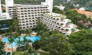 Luksusowy hotel z basenem i palmami, otoczony bujną zielenią, przypomina tropikalny raj, prawdziwe shangri la.