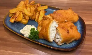 Knuspriges Fish and Chips Rezept: goldbraun frittierter Fisch mit Pommes, dazu Remoulade und Petersilie.