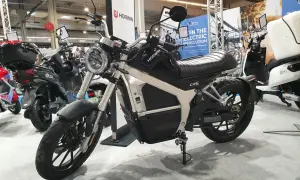 Czarny motocykl elektryczny Horwin CR6 na wystawie, obok innych pojazdów elektrycznych.