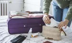 Pakowanie leków do bagażu podręcznego, by wiedzieć jak przewozić leki w samolocie Ryanair. W kosmetyczce tabletki, obok maseczka i płyn do dezynfekcji.