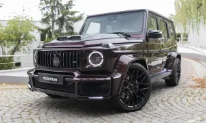 Mocarny Brabus 700 w bordowym kolorze, z czarnymi felgami i charakterystycznym grillem, prezentuje się imponująco na brukowanej nawierzchni.