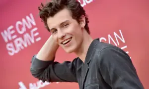 Uśmiechnięty Shawn Mendes na tle napisu "We Can Survive". Czeka na swój **shawn mendes koncert**.