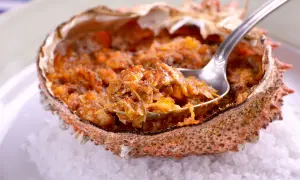 Txangurro a la donostiarra, un delicioso relleno de marisco en su caparazón, listo para ser degustado con una cuchara.