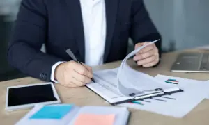 Biznesmen analizuje dokumenty, zastanawiając się, wadium co to jest i jak wpływa na transakcję.
