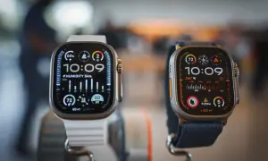 Deux montres connectées Apple, l'une avec bracelet blanc, l'autre bleu, affichent l'heure et des données météo.