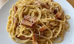 En portion riktig carbonara med spaghetti, knaprigt sidfläsk och rikligt med parmesanost.