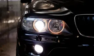 Gros plan sur les feux de position couleur d'une voiture noire, illuminant la nuit.