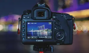 Aparat Canon z ekranem pokazującym nocną panoramę miasta. Dowiedz się, jak robić zdjęcia w ciemnych pomieszczeniach bez lampy, wykorzystując ustawienia aparatu.