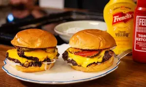 Två saftiga hamburgare med smält ost, pickles och lök. Perfekt för ett gott hamburgare recept.