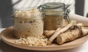 Domowy chrzan do słoików: świeże korzenie chrzanu i gotowy produkt w słoikach. Idealny do przygotowania według przepisu "jak zrobic chrzan domowy do sloikow".