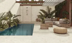 Piscina y zona lounge con sofás y mesas bajas, ducha exterior y plantas exuberantes. El suelo y las paredes lucen un elegante microcemento exterior.