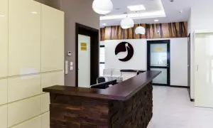 Nowoczesna recepcja kliniki Bocian Katowice. Elegancka lada, logo bociana i stylowe oświetlenie tworzą przyjazną atmosferę.