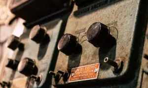 Stare pokrętła na panelu urządzenia Sun Electric Corporation. Widać napis "CONDENSER VACUUM REGULATOR" i adres firmy. To może być część starego warystora.