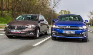 Brązowy fiat tipo sedan i niebieski Citroën jadą obok siebie po drodze.