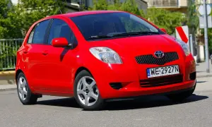 Czerwony Toyota Yaris 2008 z polskimi tablicami rejestracyjnymi WE 2927N jedzie po ulicy.