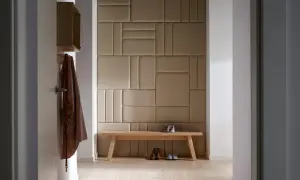 Nowoczesny przedpokój inspiracje ściany: tapicerowane panele tworzą geometryczną mozaikę, drewniana ławka z butami i kapeluszem.