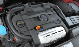 Silnik 1.4 TSI z widocznym logo VW. Czarna pokrywa silnika z napisem TSI i pomarańczową miarką oleju.