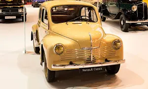 En gul, klassisk Renault 4CV står i förgrunden, en av många gamla Renault modeller på utställningen.