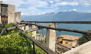 La **limonaia la malora** domina il lago, con le sue strutture in legno e le montagne sullo sfondo.