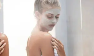 Donna con maschera viso, un rituale di bellezza prima o dopo la doccia per una pelle radiosa.