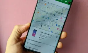 Mano sujetando un móvil que muestra la función de localizar móvil. Se ve un mapa de la Ciudad de México y opciones para reproducir sonido o proteger el dispositivo.