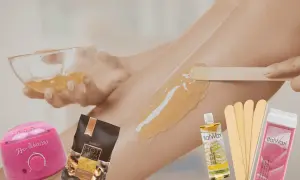 Domowa depilacja woskiem: podgrzewacz, wosk w granulacie i roll-on, szpatułki i olejek po zabiegu.