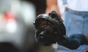 Mechanik pokazuje element pompy wspomagającej hamulce, wyjaśniając, jak działa serwo hamulcowe.