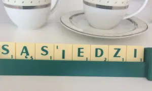 Litery z gry planszowej układają się w napis "SĄSIEDZI". Może to być art. 107 zakłócanie spokoju, gdy sąsiad jest głośny.
