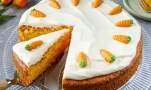 Saftiger Karottenkuchen mit Frischkäse-Frosting, dekoriert mit kleinen Marzipan-Karotten. Ein tolles Rezept für jeden Anlass!