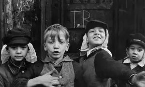 Bambini con cappelli, un'immagine che ricorda i grandi fotografi famosi, con un'espressione vivace e un gesto di invito.