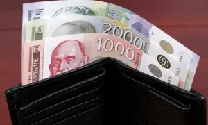 Czarny portfel wypełniony banknotami serbskie dinary. Widać nominały 1000 i 2000.