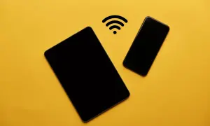 Dos dispositivos Android, una tablet y un teléfono, conectados por un símbolo de Wi-Fi, listos para compartir datos.