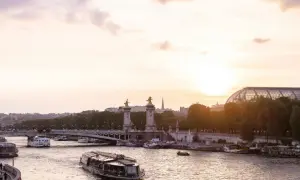Boote auf der Seine bei Sonnenuntergang, eine malerische Szene, die die beste Reisezeit Paris widerspiegelt.
