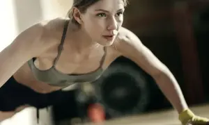 Kobieta w sportowym topie wykonuje pompki, ćwicząc różne rodzaje pompek.