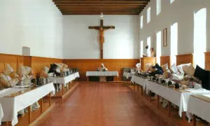 Mönche in der Kartause Marienau speisen schweigend an langen Tafeln unter einem Kruzifix.
