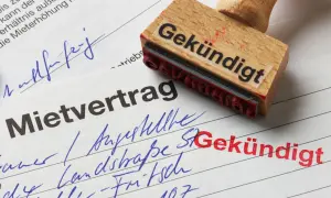 Mietvertrag mit Stempel "Gekündigt". Einer der Mieter zieht aus.