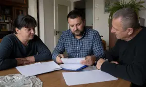 Rodzina przy stole omawia dokumenty. Czy u notariusza muszą być wszyscy spadkobiercy?