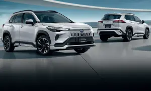 Dwa białe SUV-y Toyota Corolla Cross 2025 stoją na betonowej podłodze, jeden z przodu, drugi z tyłu.