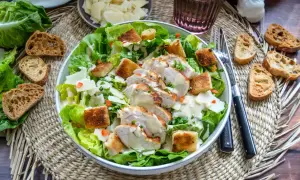 Ein köstlicher Cesar Salat mit gegrilltem Hähnchen, Croutons und cremigem Dressing. Dazu passen geröstete Brotscheiben.
