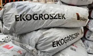 Stos worków z ekogroszkiem, widoczne napisy "EKOGROSZEK" i "Popularny".