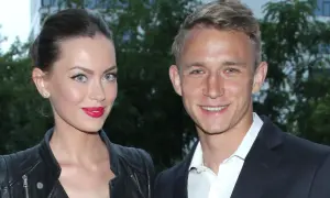 Edyta Zając i Jakub Rzeźniczak uśmiechają się do obiektywu. Ona w skórzanej ramonesce i z mocnym makijażem, on w eleganckim garniturze.