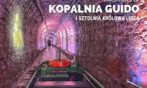 Podziemny spływ w kopalni Guido. Łódź płynie przez oświetlony tunel z kamiennymi ścianami.