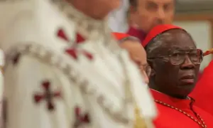Kardynał w okularach, w czerwonej sutannie, obok duchownego w białej szacie z krzyżami. Może to być przyszły czarny papież.