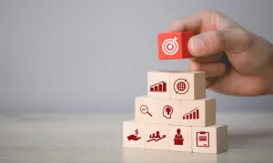Budowanie strategii marketingowych: klocki symbolizują analizę, pomysły, wzrost, globalny zasięg i cel. Podstawa to marketing fundamentals.