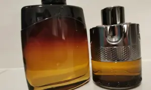 Dwa flakony perfum: jeden z gradientem od czerni do bursztynu, drugi z metalicznym wykończeniem i napisem AZZARO. Idealne na noc.
