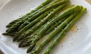 En tallrik med nykokt sparris, lätt smörad och strödd med flingsalt och peppar. Perfekt för att koka sparris!