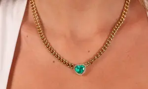 Collar de oro con colgante de corazón de esmeralda y diamantes. Un ejemplo de nombres de joyas que evocan elegancia y amor.