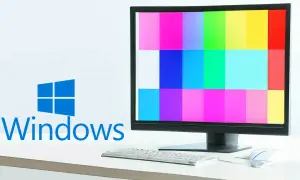 Monitor z kolorowymi pasami, logo Windows i klawiatura.